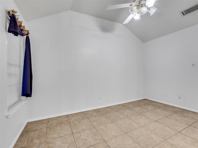 empty room featuring light tile patterned floors, visible vents, ceiling fan, and lofted ceiling