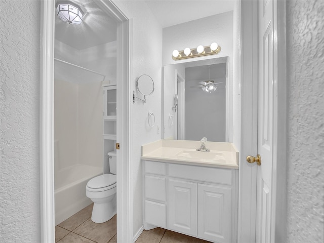 bathroom with a textured wall, vanity, toilet, tile patterned floors, and shower / bath combination