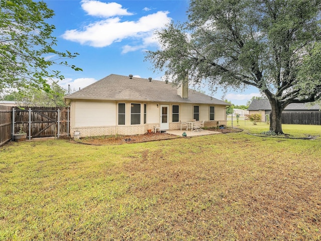 back of property with a gate, a patio area, brick siding, a fenced backyard, and a yard