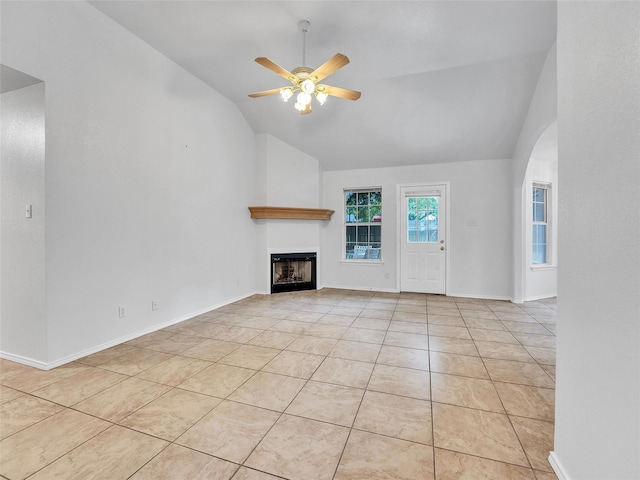 unfurnished living room featuring a fireplace, ceiling fan, high vaulted ceiling, arched walkways, and light tile patterned floors