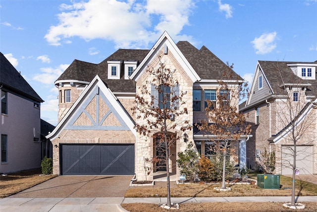 view of front of house featuring a garage, stone siding, concrete driveway, and brick siding