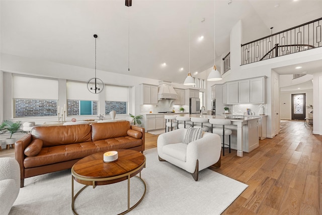 living area featuring light wood-style flooring and a towering ceiling