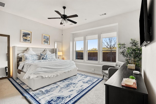 carpeted bedroom featuring baseboards, a ceiling fan, and visible vents
