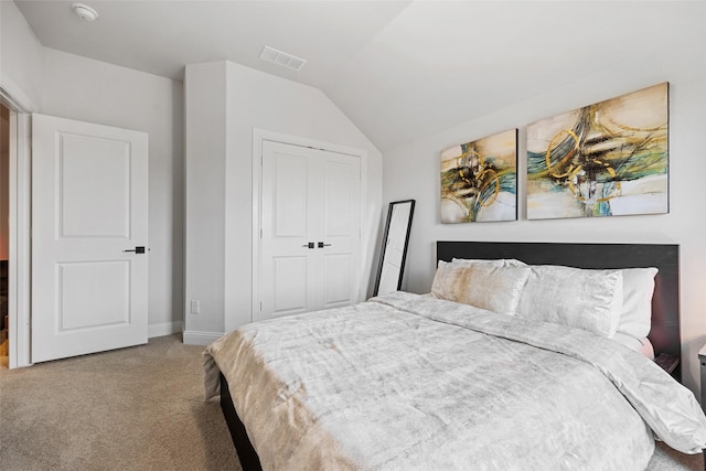 bedroom featuring visible vents, a closet, lofted ceiling, baseboards, and carpet flooring