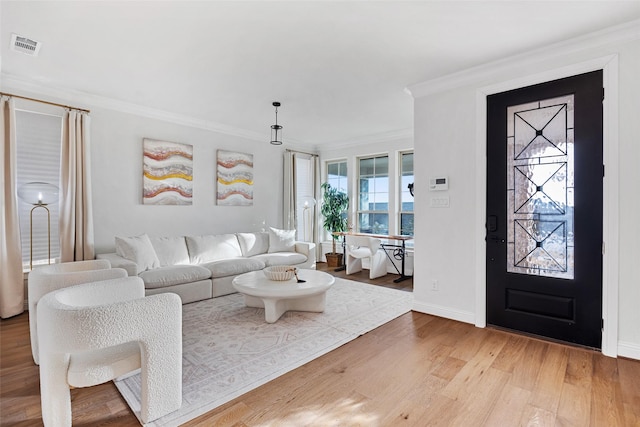 living room featuring crown molding, baseboards, visible vents, and light wood-style floors