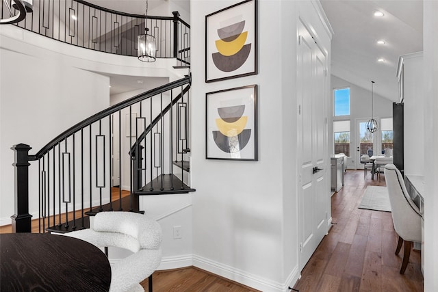 staircase featuring wood-type flooring, baseboards, high vaulted ceiling, recessed lighting, and a chandelier