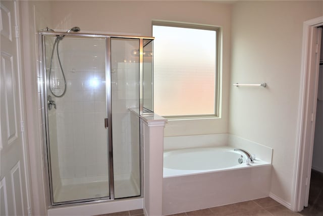 bathroom featuring plenty of natural light, a bath, a stall shower, and tile patterned flooring