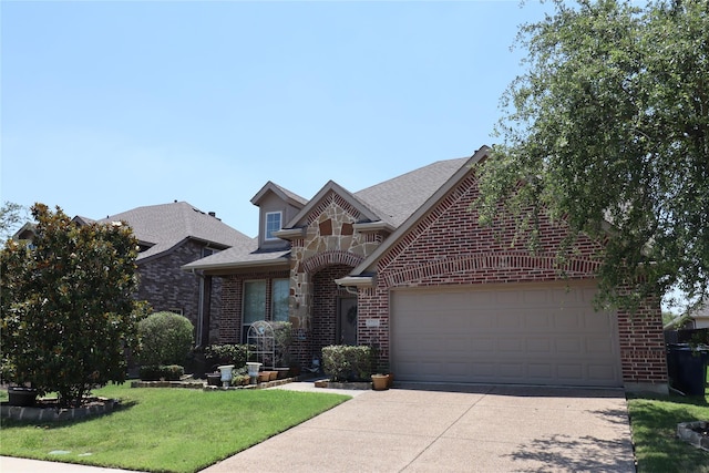 traditional home featuring a shingled roof, an attached garage, a front lawn, brick siding, and driveway