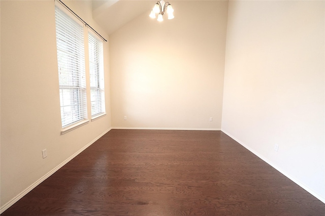 empty room with an inviting chandelier, baseboards, vaulted ceiling, and dark wood-style floors