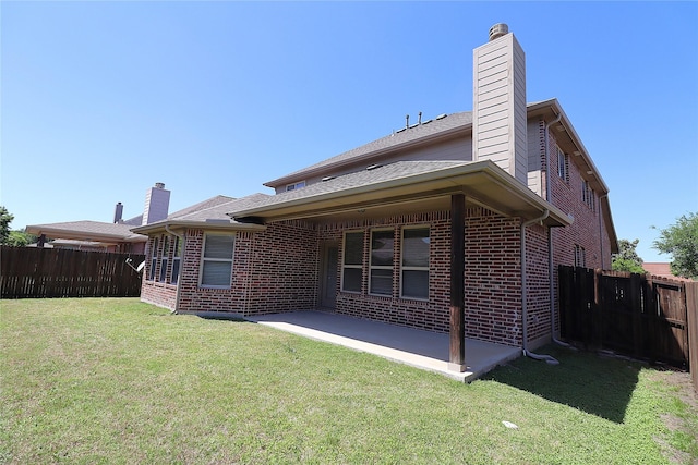 back of property featuring fence, a chimney, a patio area, and brick siding