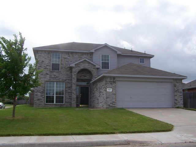 traditional-style house featuring a garage, concrete driveway, and a front yard