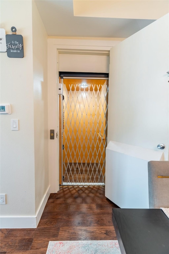 interior space featuring baseboards and dark wood-type flooring