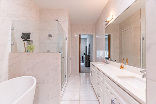 full bath with a sink, marble finish floor, a freestanding bath, and a shower stall