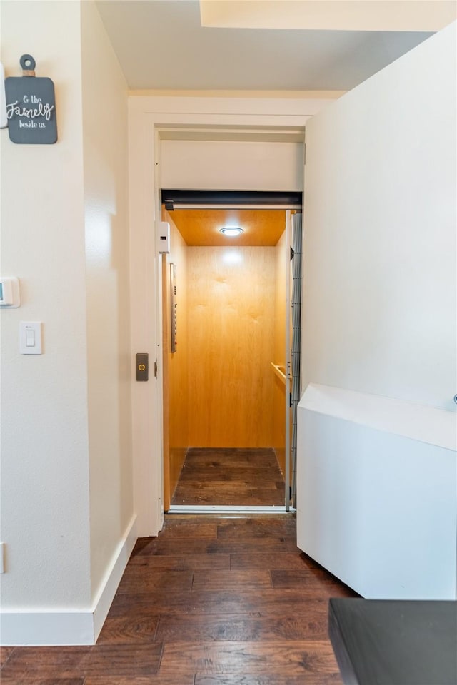 corridor with elevator and dark wood-style floors