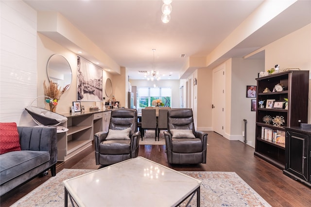 living area featuring baseboards, dark wood-style floors, and a chandelier