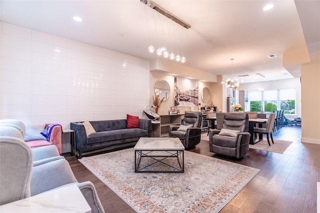 living room featuring recessed lighting, baseboards, dark wood-style flooring, and a chandelier