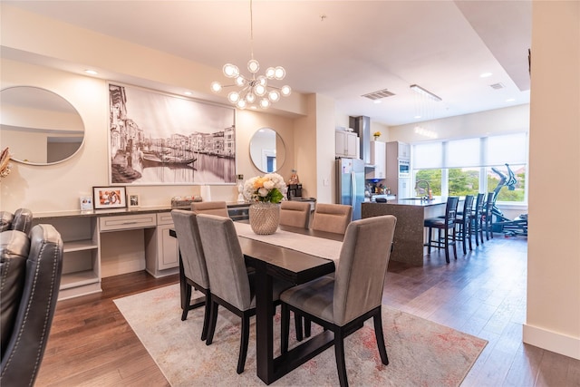 dining area with a notable chandelier, recessed lighting, hardwood / wood-style floors, and visible vents
