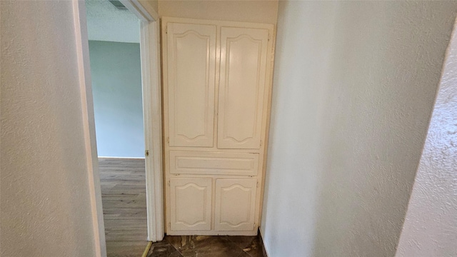 corridor with a textured wall and visible vents