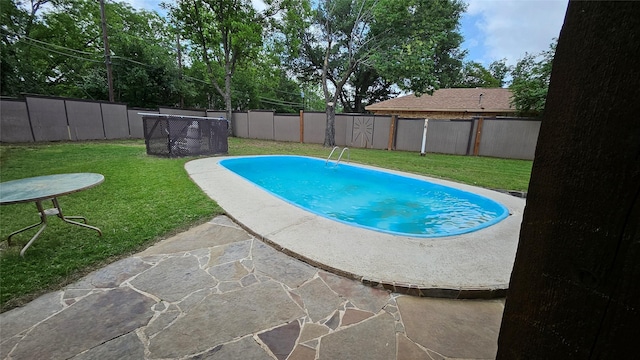 view of swimming pool with a lawn, a fenced in pool, and a fenced backyard