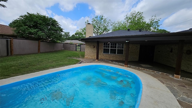 view of pool with fence and a yard