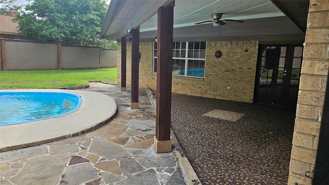 view of swimming pool with ceiling fan, fence, a patio area, and a fenced in pool