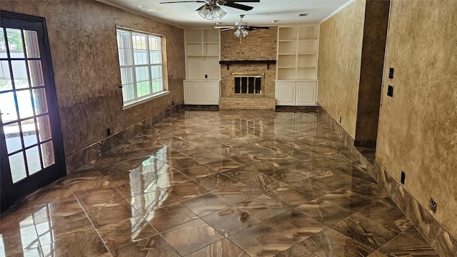 unfurnished living room with a fireplace, a ceiling fan, built in shelves, and marble finish floor