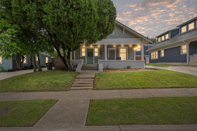 view of front of property featuring covered porch and a front lawn