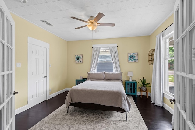 bedroom featuring multiple windows, dark wood-style floors, and visible vents