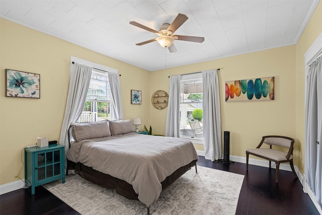 bedroom featuring baseboards, a ceiling fan, and dark wood-style flooring