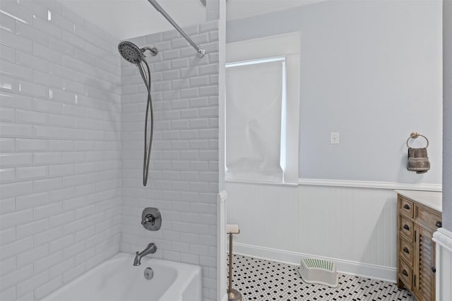 bathroom featuring shower / bath combination, baseboards, and wainscoting