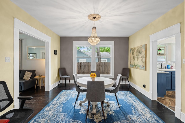dining room with baseboards, a notable chandelier, and dark wood-style floors
