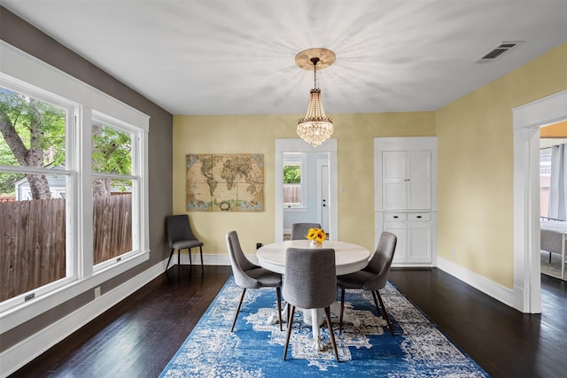 dining room with baseboards, visible vents, dark wood finished floors, and an inviting chandelier