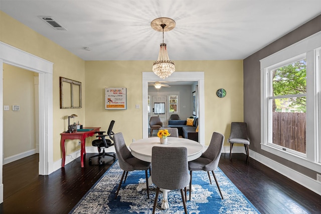 dining space featuring plenty of natural light, a notable chandelier, hardwood / wood-style flooring, and visible vents