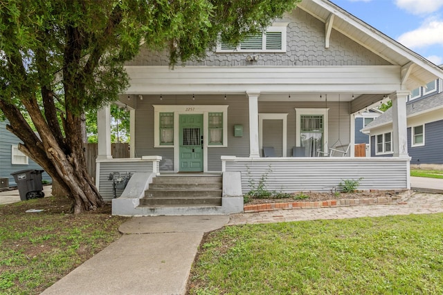 view of front of house with covered porch and a front yard