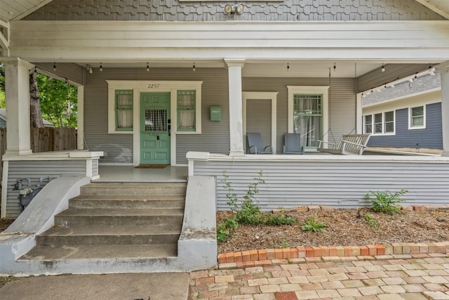 view of exterior entry with a porch