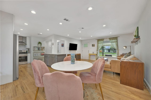 dining area with light wood-style floors and recessed lighting