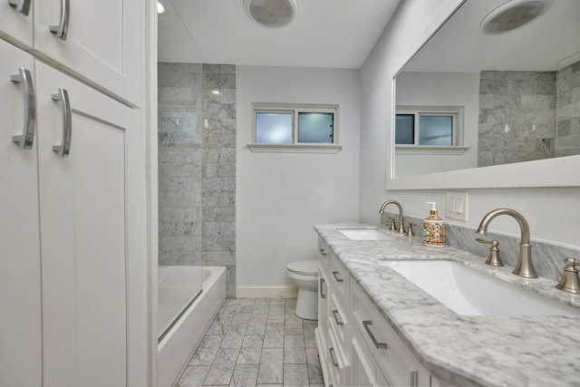 bathroom with marble finish flooring, baseboards, toilet, and double vanity