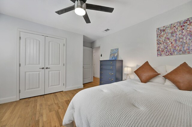 bedroom with light wood-type flooring, baseboards, a closet, and a ceiling fan