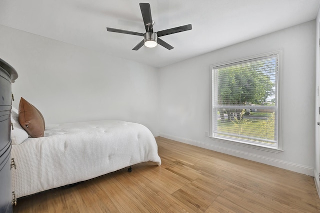 bedroom featuring wood finished floors, baseboards, and ceiling fan