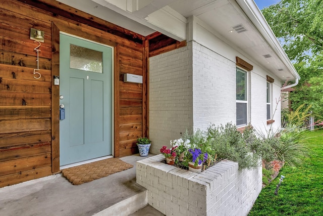 view of exterior entry with brick siding