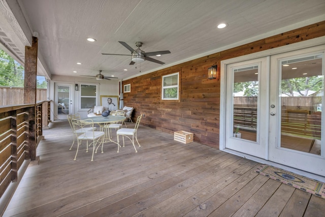 wooden deck with french doors, outdoor dining area, and ceiling fan