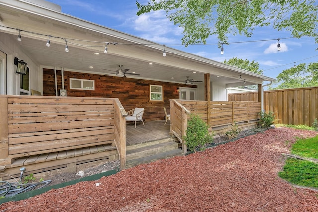 wooden terrace with ceiling fan and fence