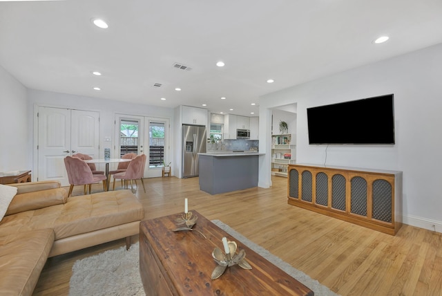 living area with recessed lighting and light wood finished floors
