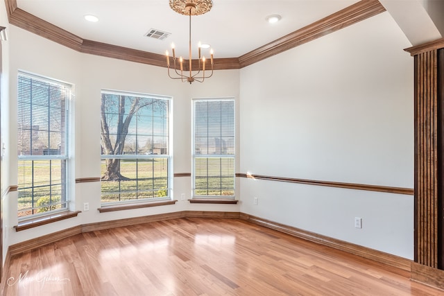 unfurnished dining area with a chandelier, visible vents, a wealth of natural light, and wood finished floors