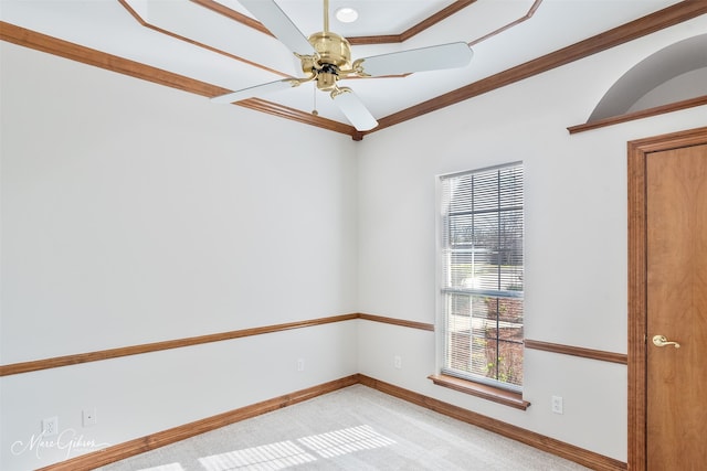 spare room featuring crown molding, baseboards, ceiling fan, and light carpet