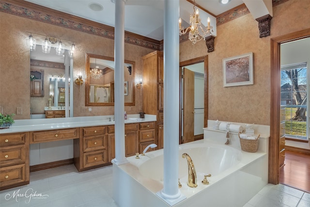 full bath with tile patterned flooring, vanity, wallpapered walls, decorative columns, and a garden tub