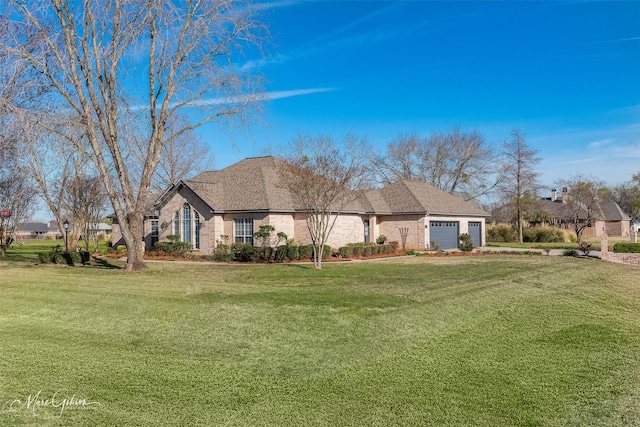 view of front of house with an attached garage and a front yard