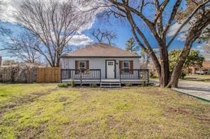 view of front of house with fence, a wooden deck, and a front yard