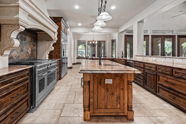 kitchen featuring light stone countertops, stone tile floors, recessed lighting, high end appliances, and a kitchen island
