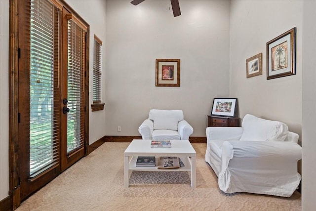 sitting room featuring carpet floors, baseboards, and ceiling fan